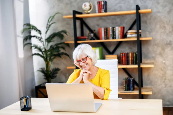 Senior woman is using laptop for work indoor — Stock fotografie