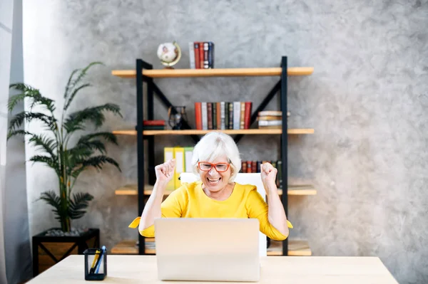Senior woman is using laptop for work indoor — Stock Photo, Image