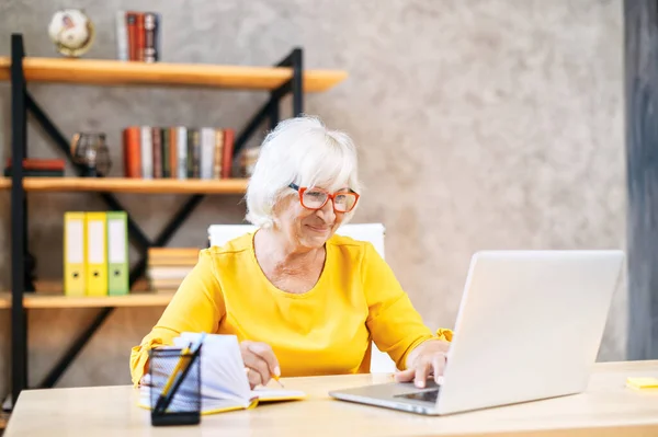 Senior woman is using laptop for work indoor — Stock fotografie