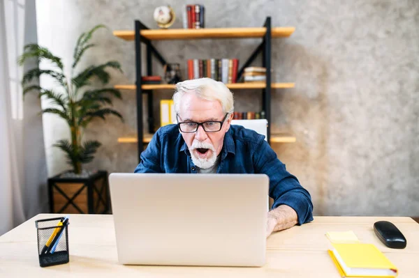 Älterer Mann nutzt Laptop zum Arbeiten im Haus — Stockfoto