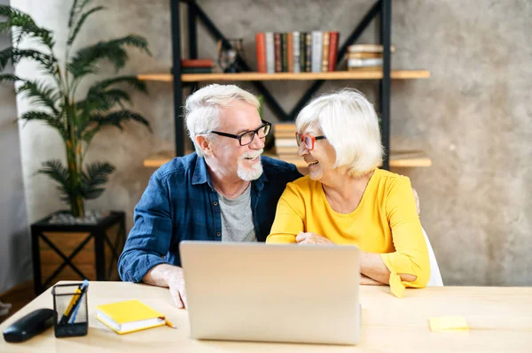 Un couple âgé heureux utilise l'ordinateur portable à l'intérieur — Photo