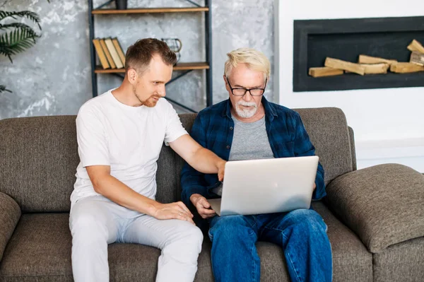 Zwei Mehrgenerationenmänner sitzen auf dem Sofa — Stockfoto