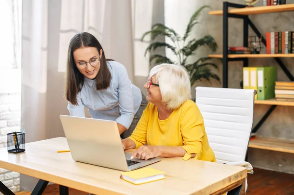 Dos compañeras en la oficina usando un portátil —  Fotos de Stock