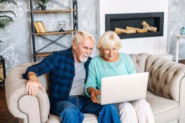 Senior koppel met een laptop binnen — Stockfoto