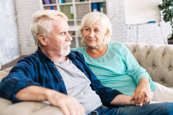 Oudere echtparen zitten thuis op de bank — Stockfoto