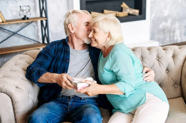 Senior man ger en gåva till äldre kvinna hemma — Stockfoto