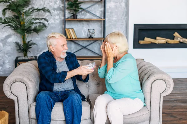 Senior man ger en gåva till äldre kvinna hemma — Stockfoto