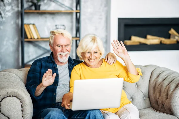 Seniorenpaar mit Laptop drinnen — Stockfoto