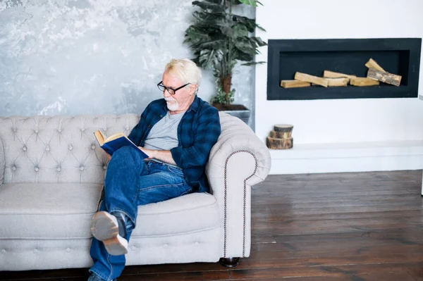 Dojrzały mężczyzna w okularach czyta książkę — Zdjęcie stockowe