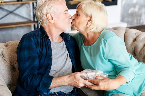 Senior man ger en gåva till äldre kvinna hemma — Stockfoto