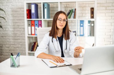 Video çağrısı için dizüstü bilgisayar kullanan kadın doktor