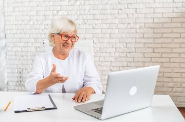 Kıdemli kadın doktor hastaya çevrimiçi danışmanlık yapıyor.