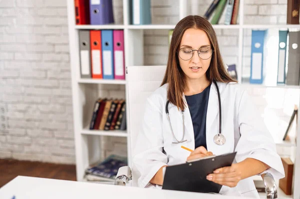 Medico femminile con un blocco a molla per appunti all'interno — Foto Stock