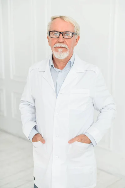 Starszy siwy lekarz na białym — Zdjęcie stockowe