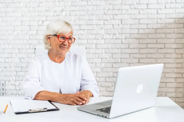 Senior female doctor consults patient online — Stock Photo, Image