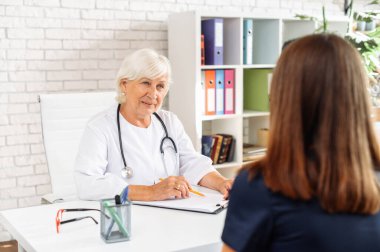 Kıdemli bayan doktor hastaya danışmanlık yapıyor.