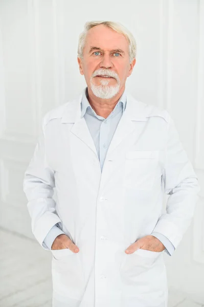 Médico masculino de pelo gris senior en blanco —  Fotos de Stock