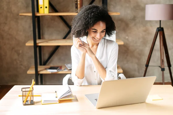 Uma jovem mulher está usando laptop no escritório — Fotografia de Stock