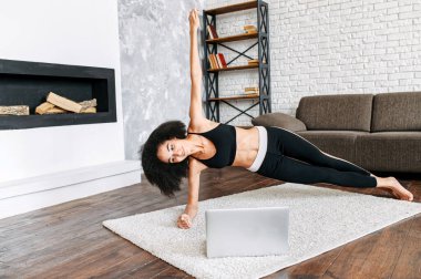 Bilgisayarlı bir kadın evde dong egzersizi yapar.