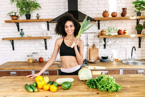 Une femme en bonne santé avec un légume à la cuisine — Photo