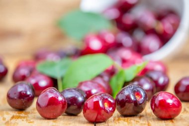 Ahşap masada beyaz kase taze kiraz