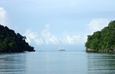 Kayaların arasında yelken tekne