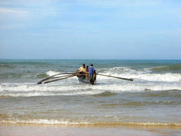 Sri Lanka, Bentota. Aralık 2011. Balıkçı tekne okyanusa dalgaları aracılığıyla inerler.                     