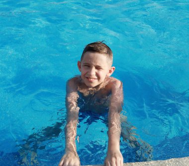 Güneşli bir günde havuzda Mutlu sevimli çocuk 