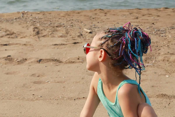 Nettes Mädchen Modischer Roter Brille Und Farbigen Zöpfen Sitzt Strand — Stockfoto