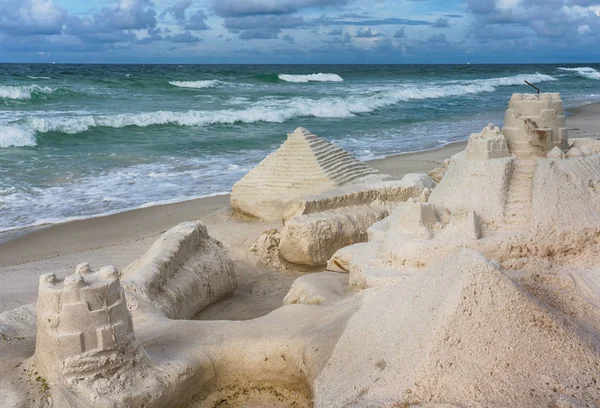 Castelli di sabbia, sabbia e surf — Foto Stock