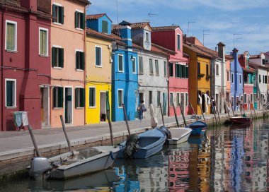 Burano ve su yansıma evlerin. Geleneksel tekneler ve renkli cephe ile su yolları. Venedik