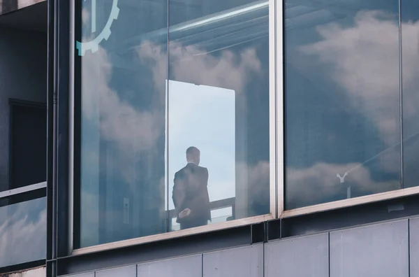 Hombre Negocios Mirando Por Encima Ventana Edificio Moderno Con Reflejo —  Fotos de Stock