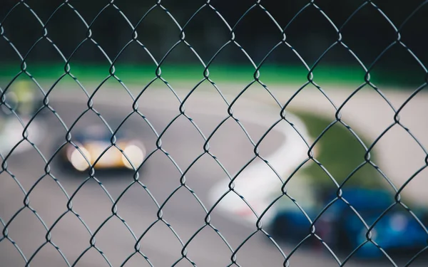 Δείτε Θολή Αγωνιστικό Αυτοκίνητο Από Ένα Μεταλλικό Πλέγμα Αθλητισμός Φόντο — Φωτογραφία Αρχείου
