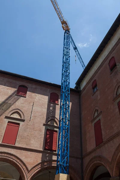 reconstruction of the facade of a old building in italy (bologna) - Construction crane during construction.