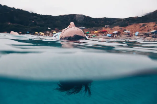 Женщина отдыхает на поверхности воды с закрытыми глазами - расслабление и концепция медитации — стоковое фото
