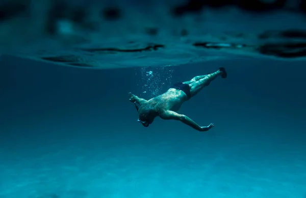 Underwater view of a Senior Man floating in beautiful ocean 70s 80s - Sardinia- italy.