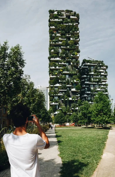 boy photographing vertical green building milan