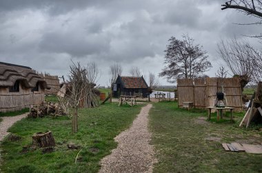 yel değirmenleri yakınındaki küçük eski köy bulutlu ve rüzgarlı bir günde - Güney Hollanda - 19 anıtsal yel değirmenleri grubu - doğal Molens .