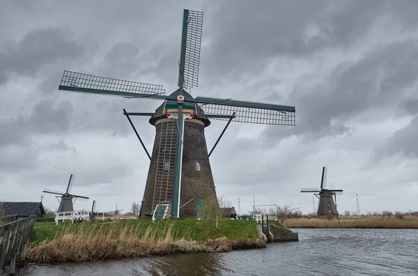 Windmills in a cloudy and windy day - South holland - Group of 19 monumental windmills - Molens of Kinderdijk. — Stock Photo, Image