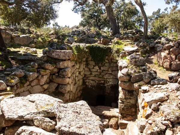 Sacred Source entrance archaeological site of Noddule in the megalithic circle and large circular hut in the new archaeological site in Sardinia , ITALY.