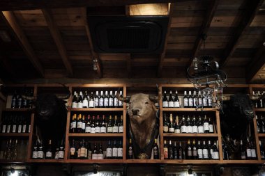 Nisan 2019 - Seville İspanya Tipik Tapas restoran iç şarap şişesi ve doldurulmuş boğa kafası mumyalama ile.
