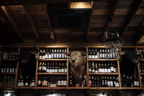 Nisan 2019 - Seville İspanya Tipik Tapas restoran iç şarap şişesi ve doldurulmuş boğa kafası mumyalama ile.