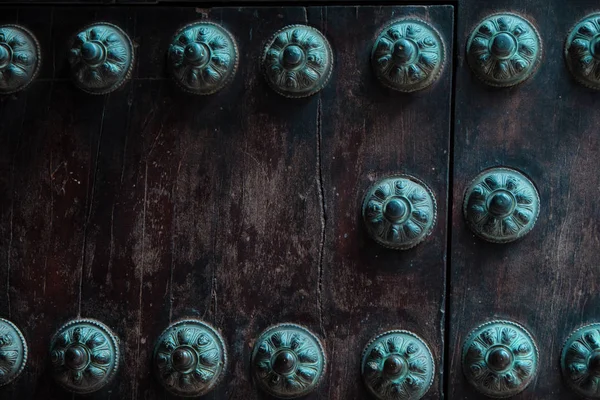 Close-up van oude bezaaid deur detail met meerdere decoratieve studs. — Stockfoto
