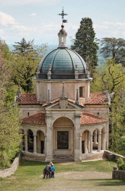 Kutsal Dağ 'dan veya Varese' deki Sacro Monte 'den tarihi hac rotası boyunca ailesinin fotoğrafını çeken bir kadın.