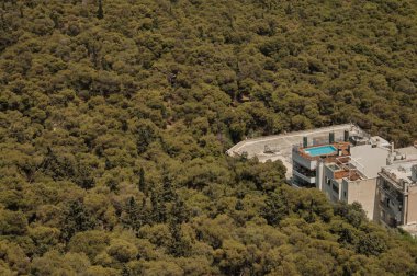 Atina Yunanistan'da ağaçlarla çevrili yüzme havuzu ile bina görünümü.