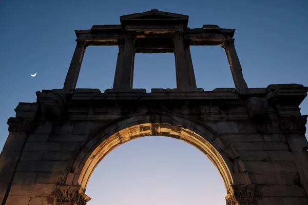 그리스 아테네에서 달과 일몰 동안 아치 하드리안 아치 사원 올림피아 제우스 아테네의 유적의 보기 - 낮은 빛. — 스톡 사진