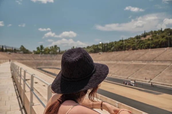 Kvinna eller flicka med sol hatt ser Panathenaic Stadium från läktare i en solig dag. — Stockfoto