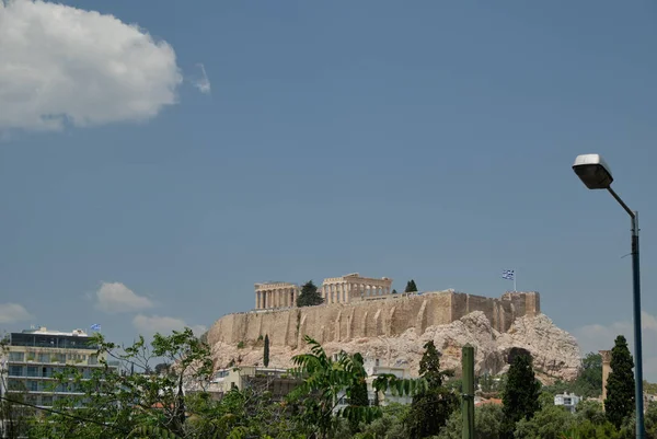 ギリシャの首都で晴れた日にアクロポリスの古代寺院と澄んだ青空と雲 - アテネ. — ストック写真