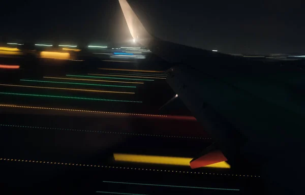 Operacja odlotu w nocy z kolorowymi próbami ruchu świetlnego-przed upadkiem lądowania samolotu. — Zdjęcie stockowe