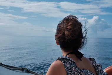 Nostaljik üzgün kız ya da güneşli bir günde küçük bir tekneden denize bakan yalnız kadın..